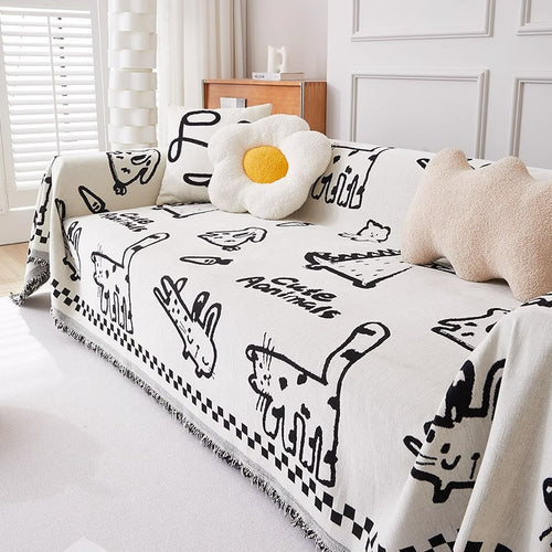 Sofa with a white Pet Sofa Covers featuring black cat illustrations, surrounded by cushions.